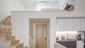 Een modern interieur met een trap, een keuken en een bank.