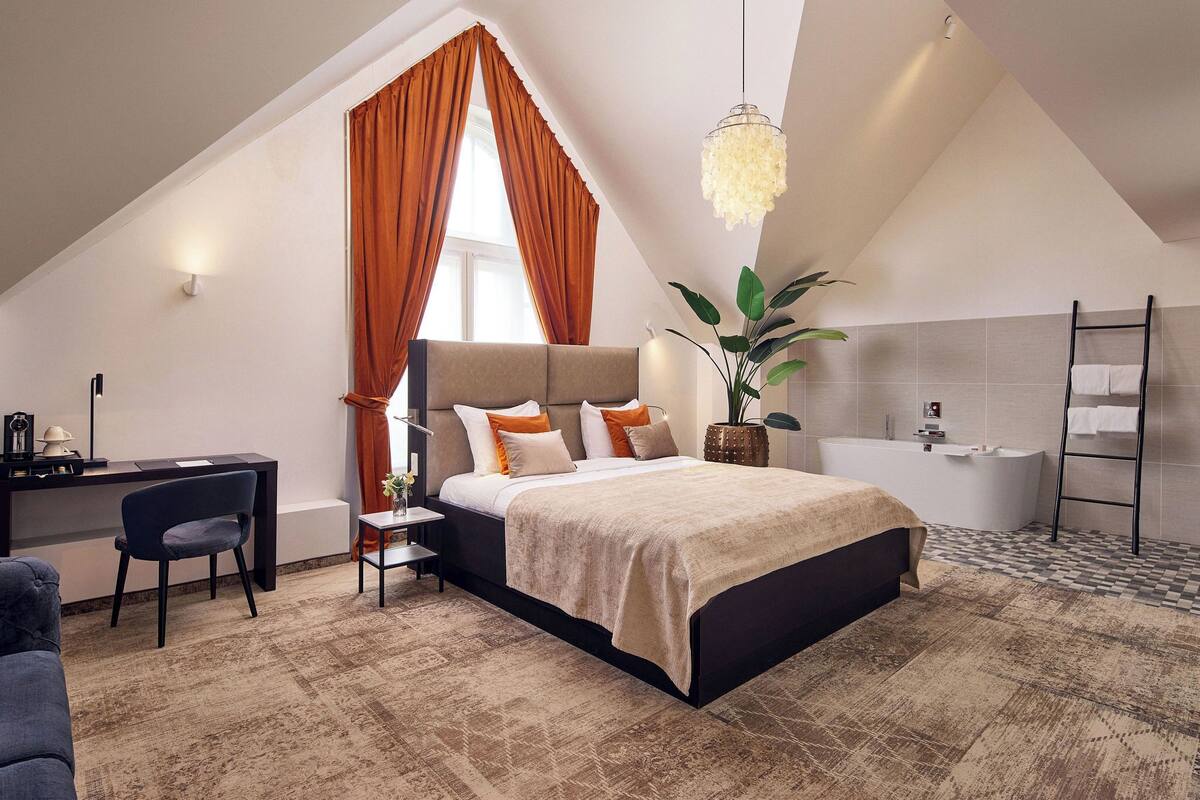 Ein modernes Schlafzimmer mit einem großen Bett, einem Schreibtisch und einer Badewanne.