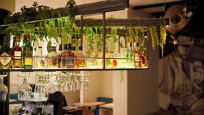 A bar area with shelves of liquor bottles and hanging wine glasses. - Van der Valk Hotel Mechelen (Mechelen)