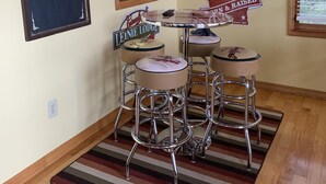 Ein gemütlicher Barbereich mit Hockern, einem Kreidetafel-Schild mit der Aufschrift 'Best Beers' und einem Schild mit der Bezeichnung 'Leine Lodge'.