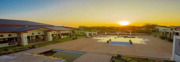 Una piscina al aire libre, sombrillas, sillones reclinables de piscina