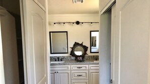 A bathroom with white cabinetry, a granite countertop, a sink, and two mirrors. - Serene Sedona Studio w/ double shower and private patio with view! (Sedona)