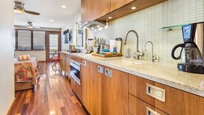 Eine moderne Küche mit Holzschränken, einer Granit-Arbeitsplatte und einer Kaffeemaschine.