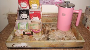 En kaffedisplay med en skylt som lyder: ”Ta en liten kaffepaus” och en rosa kaffebryggare.
