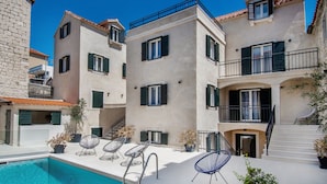A courtyard with a swimming pool, outdoor seating, and a staircase leading to an upper floor. - Sperone Luxury Accommodation (Split)