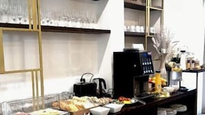 A buffet setup with various food items and condiments, a coffee machine, and decorative elements on shelves. - Sperone Luxury Accommodation (Split)