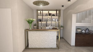 A reception area with a modern desk, a vase of flowers, and a shelving unit with various decorative items. - Sperone Luxury Accommodation (Split)