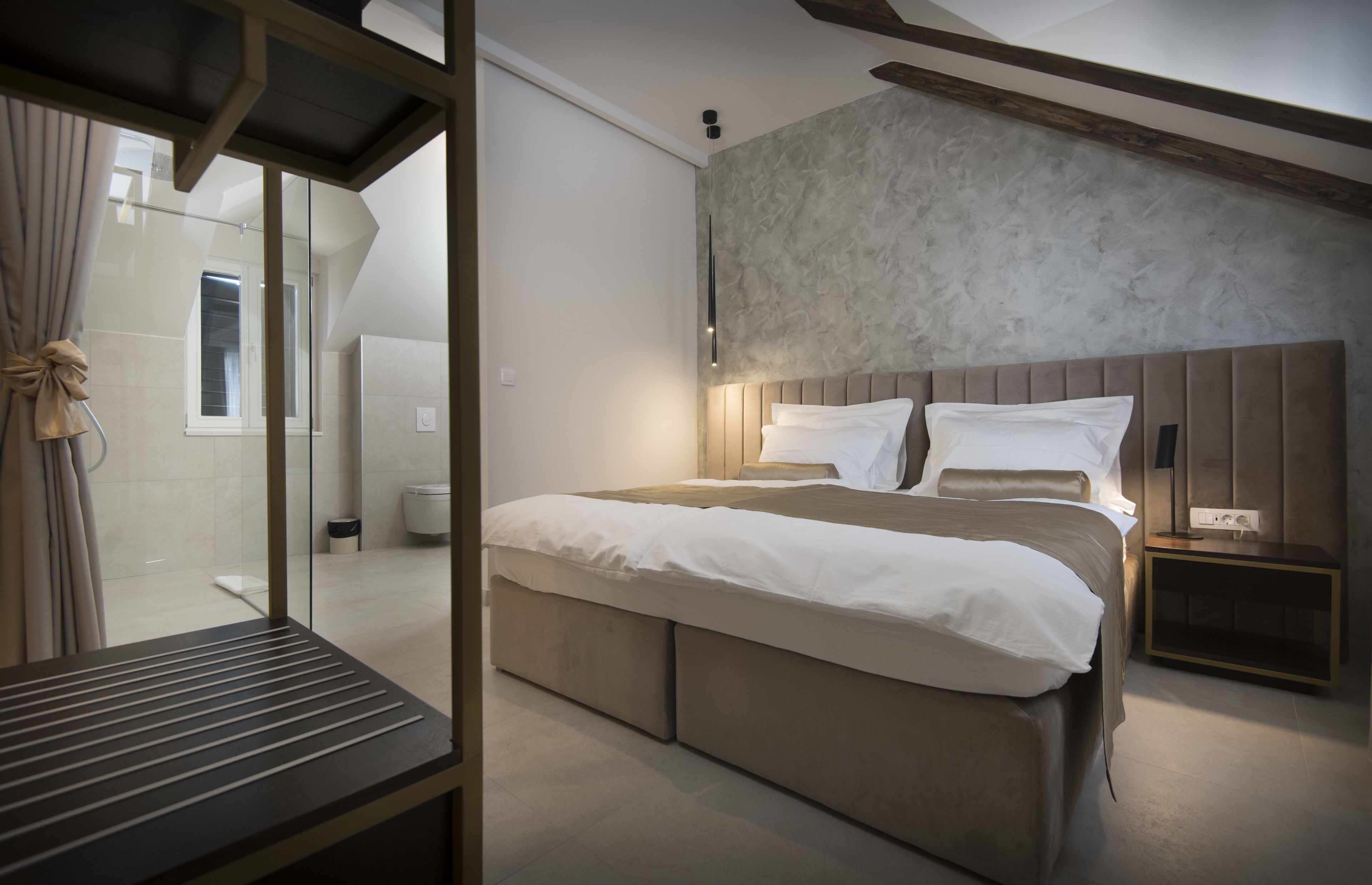 Un dormitorio moderno con una cama grande, una mesita de noche y vistas al baño.