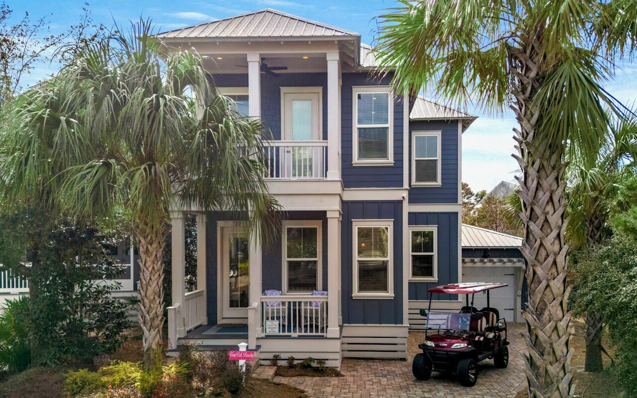 A two-story house with a porch, a covered patio, and a golf cart.