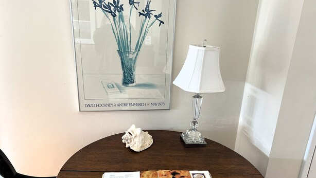 A dining table with a book open to a pasta recipe, a decorative shell, a lamp, and a framed artwork. - Village home in Suttons Bay. Walk to everything. Air, grill, WIFI (Suttons Bay)