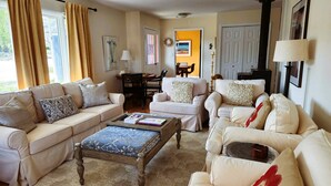 A living room with two sofas, a coffee table, and a dining table with chairs. - Village home in Suttons Bay. Walk to everything. Air, grill, WIFI (Suttons Bay)