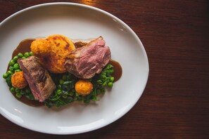 A plate of food with meat, potatoes, and peas.