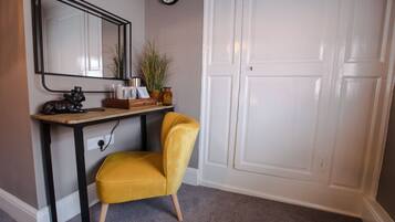 Una habitación con un escritorio, una silla, un reloj y una puerta blanca.