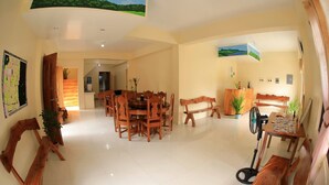Uma ampla sala de jantar com mobiliário de madeira e um mural no teto.