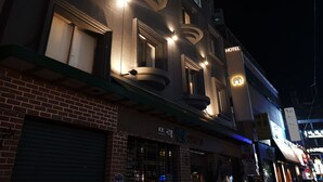 A hotel with multiple windows, a balcony, and a sign indicating it is a hotel. - Hotel Elephant (Busan)
