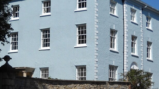 A multi-story building with a light blue facade and white window frames.