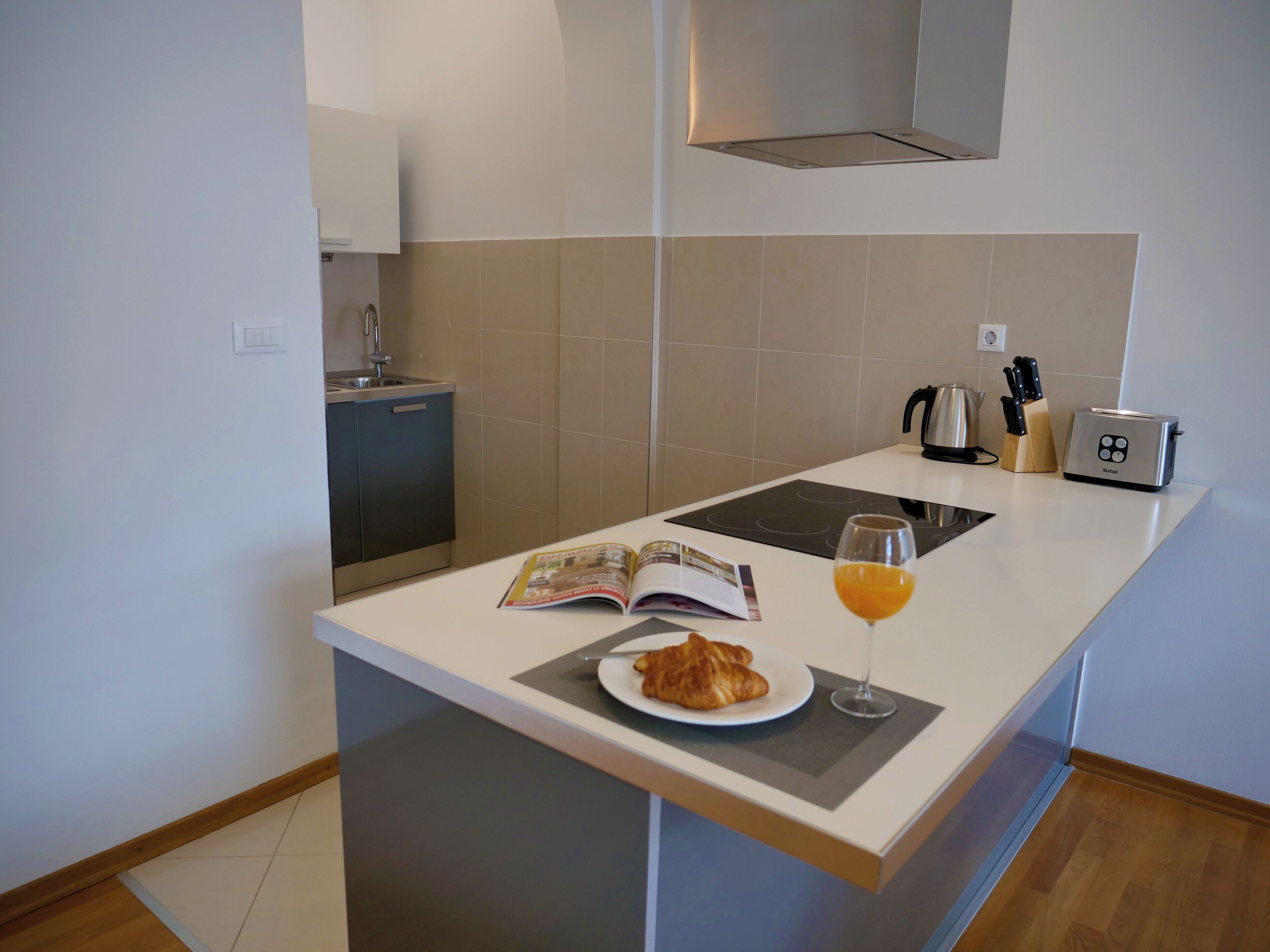 Una cucina moderna con forno a incasso, tostapane e lavello.