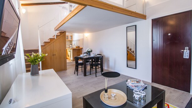 A modern interior with a dining area, kitchen, and staircase. - Furioso Apartments (Split)