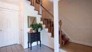A staircase with wooden railings and a white door. - 3.5 miles to Washington DC- Family Size Spacious 4BDR + Parking (Arlington)