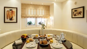 A dining area with a table set for breakfast, including plates, cups, and a vase with flowers. - SUNLIGHT VILLA WITH PRIVATE POOL  FOR FAMILIES AND FRIENDS TO ENJOY (Myrtia)