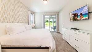 Une chambre à coucher avec un lit, une télévision, une commode et une vue sur l’extérieur.