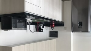 A modern kitchen with white cabinetry, a black countertop, and stainless steel appliances including a refrigerator and a coffee maker. - Suite Riviera 211 *Rooftop Pool* (Playa del Carmen)
