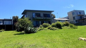 A residential building with a flat roof, a balcony, and a grassy yard. - Unit 3 Beachside units.  Pambula Beach (Pambula Beach)