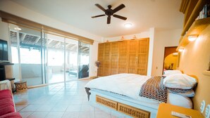 A bedroom with a bed, a ceiling fan, a sliding glass door, and a television. - Sleeps 6, amazing La Ropa bay views, newly available , over 3000 square feet! (Zihuatanejo)