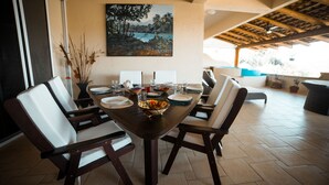 A dining area with a wooden table set for four, surrounded by chairs. - Sleeps 6, amazing La Ropa bay views, newly available , over 3000 square feet! (Zihuatanejo)