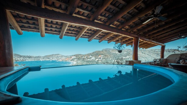 A hot tub with a view of the sea and hills. - Sleeps 6, amazing La Ropa bay views, newly available , over 3000 square feet! (Zihuatanejo)
