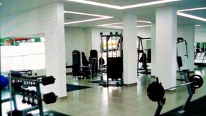 Un gimnasio con diferentes equipos de ejercicio, que incluyen máquinas de pesas y pesas libres.