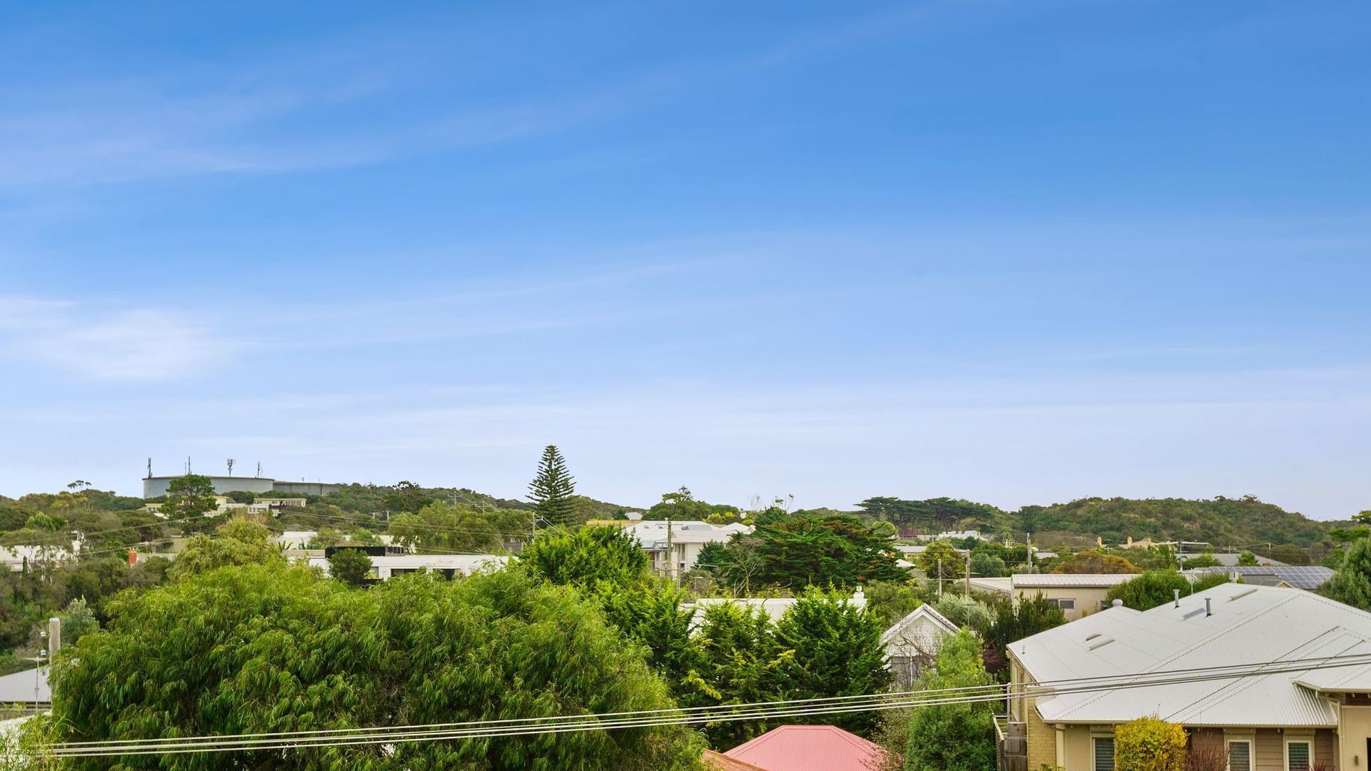 Un quartier résidentiel avec des maisons, des arbres et un ciel bleu dégagé.
