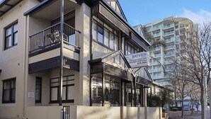 A multi-story building with balconies, a sign for Bayview offering fully equipped 2-bedroom suites, and a nearby sign for Buffalo.