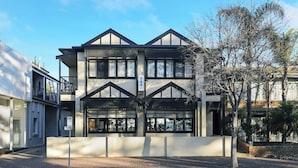 A modern building with a symmetrical facade, large windows, and a visible address sign.