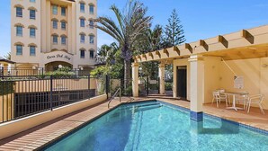 Un espace piscine offrant une vue dégagée sur la piscine, un pergolas et, au fond, un bâtiment portant l’inscription « Casa Del Rey ».