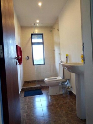 Un baño pequeño con inodoro, lavamanos y ventana.