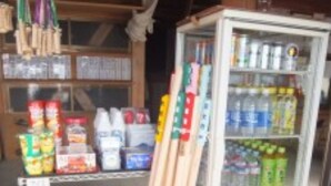 A vending machine stocked with beverages and snacks, with wooden sticks leaning against it. - Mt.Fuji Fujinomiya Trail The New 7th Station Goraikousansou (Fujinomiya)