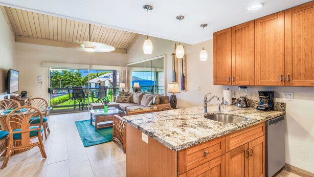 Una cocina amplia con armarios de madera, encimera de granito y vistas al exterior.