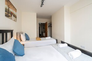 A hotel room with two beds, a painting on the wall, and a coat rack. - Nice 3 Bedrooms Apartment Near Hyde Park & Oxford St (London)