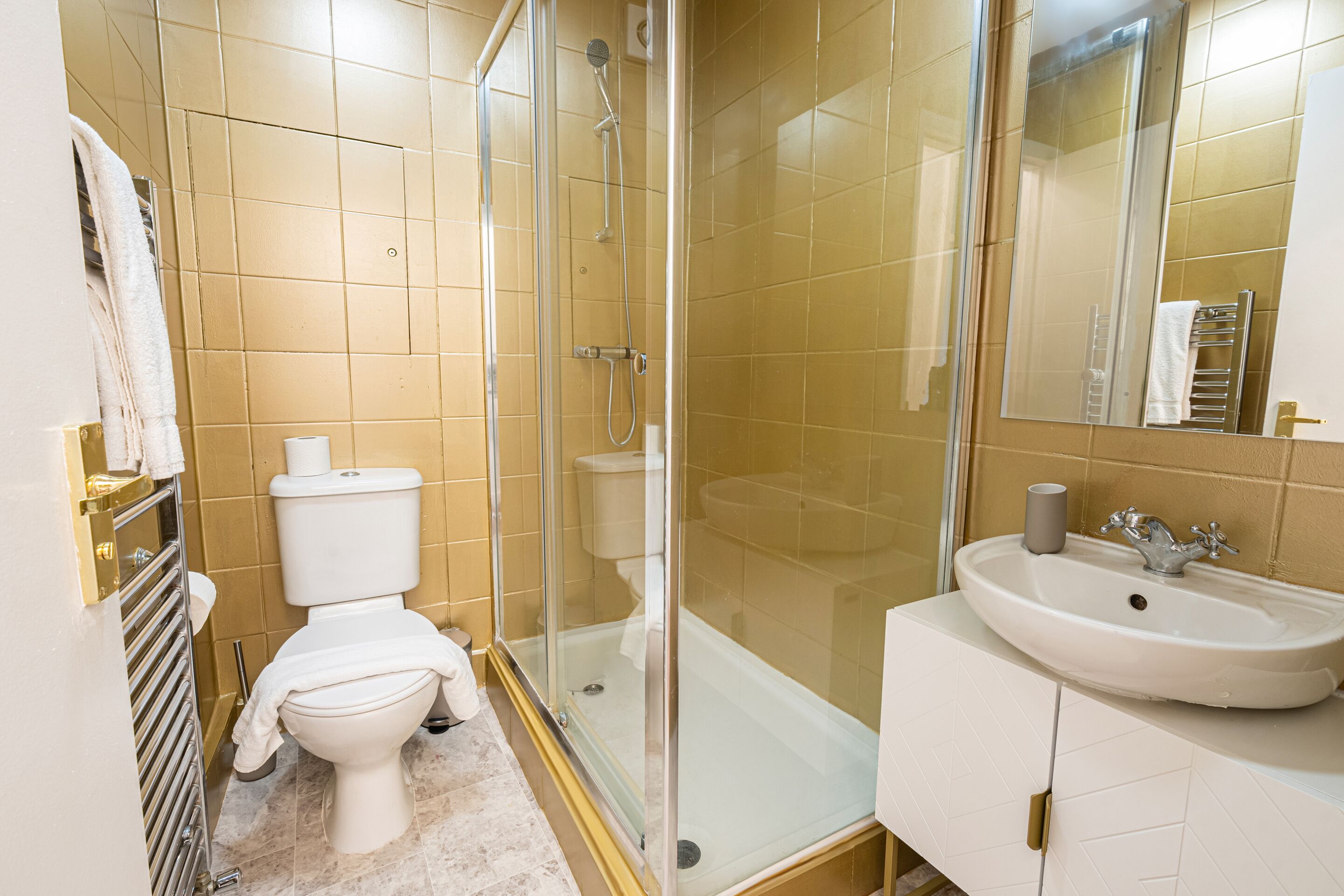Une salle de bain avec des toilettes, une douche et un lavabo.