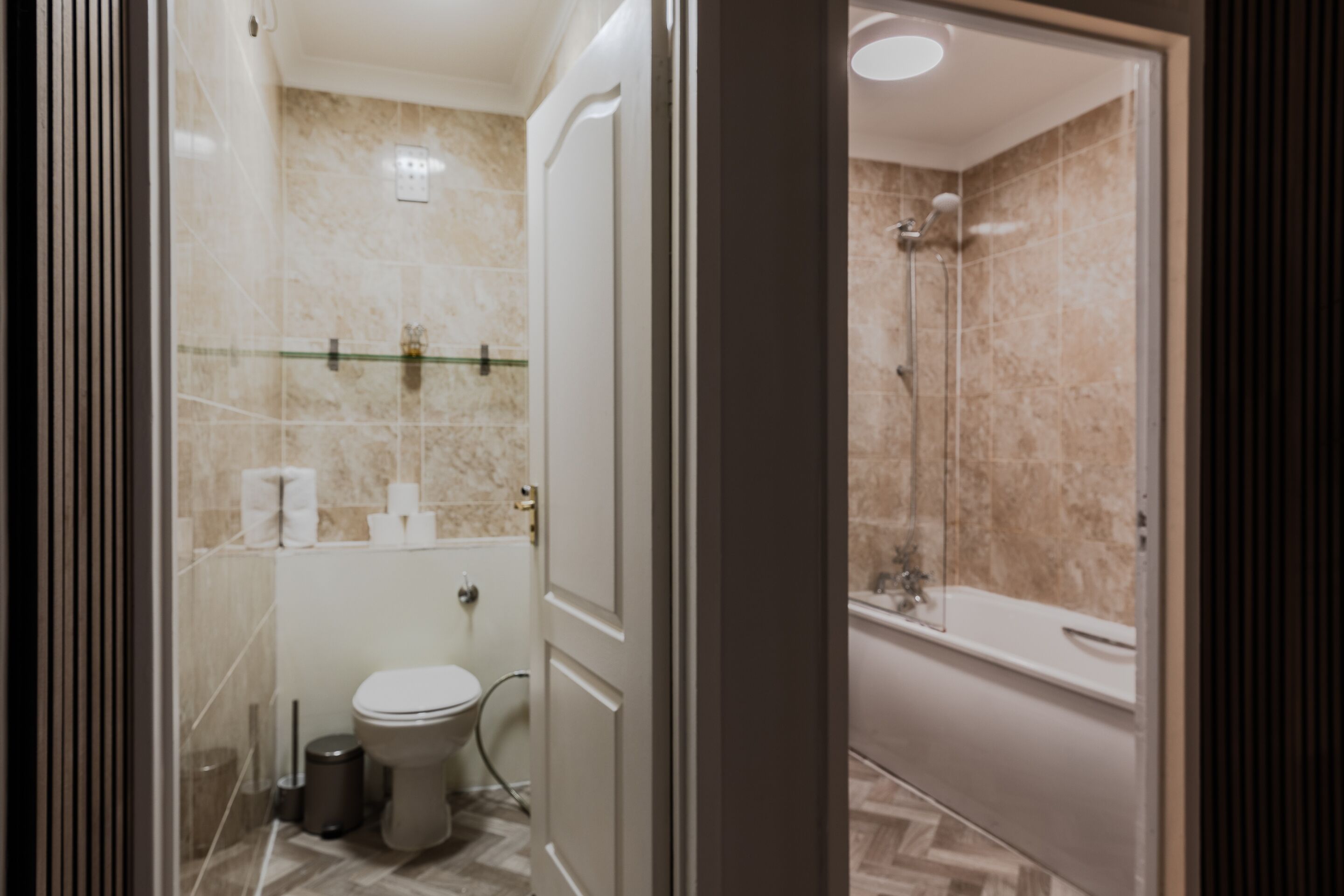 Een badkamer met toilet, hygiëneschuimer en douche.