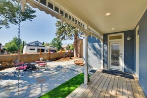 A covered patio with a table and chairs, a wooden deck, and a house with a blue exterior. - 0547: Downtown Salida Home, 1 Block to Main Street (Salida)
