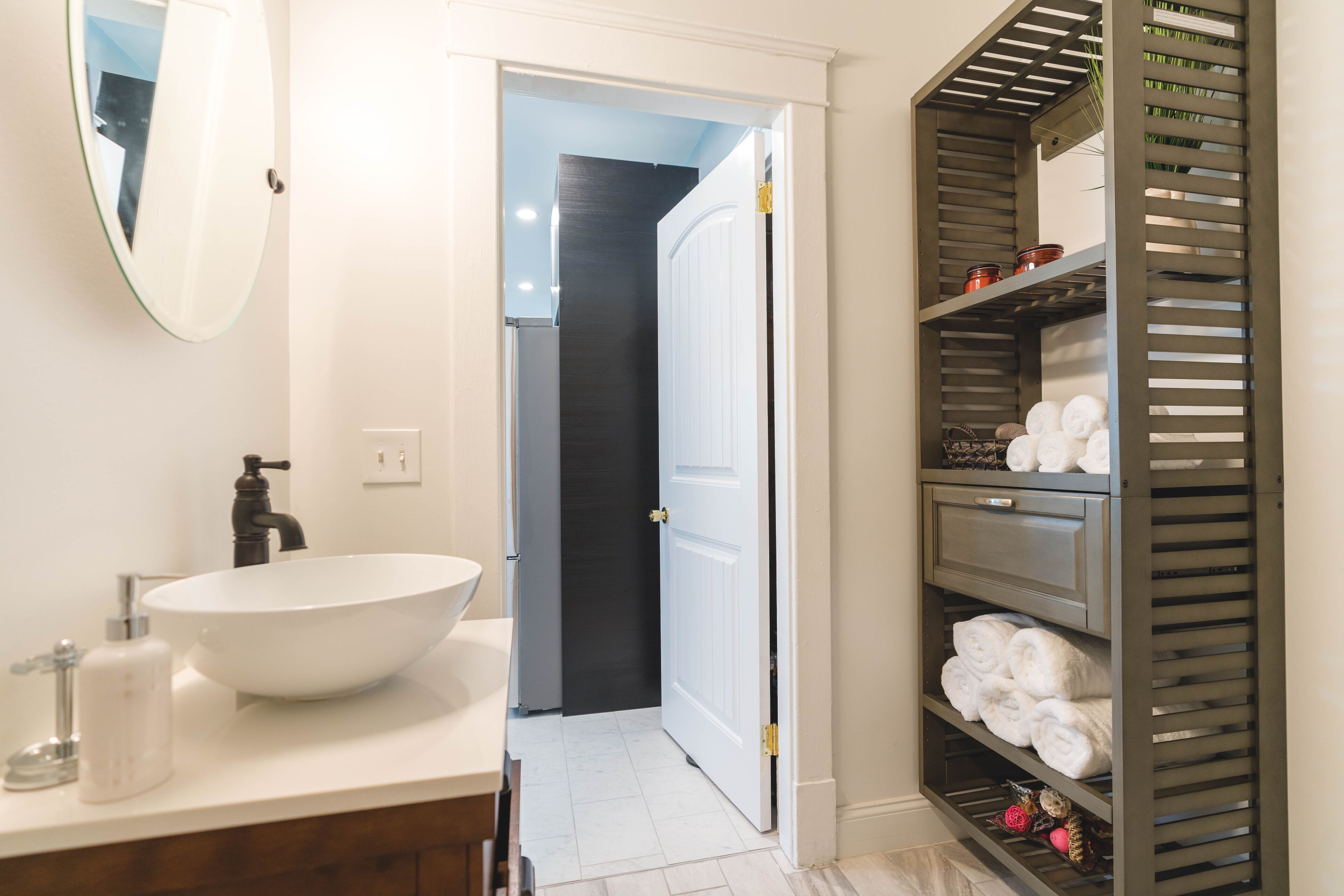 A bathroom with a white sink, a mirror, and a towel rack.