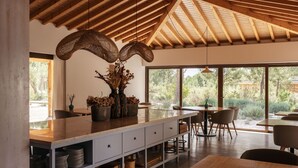 Una cocina moderna con techo de madera, ventanas amplias y una isla central con sillas.