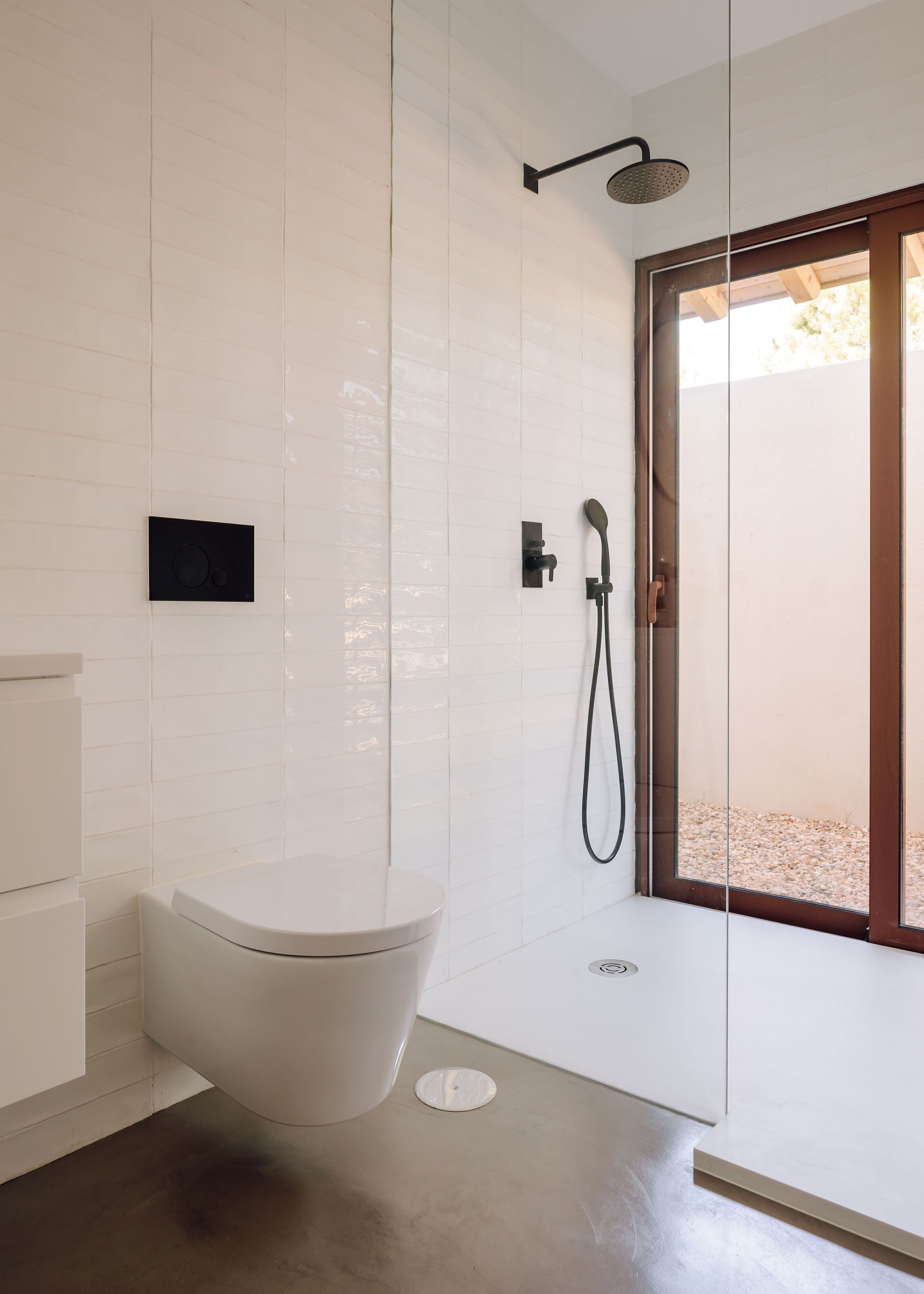 Un baño moderno con una bañera independiente, una zona de ducha con mampara de vidrio y un inodoro.