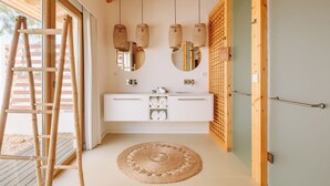 Un baño moderno con techo de madera, tocador blanco y un espejo grande.