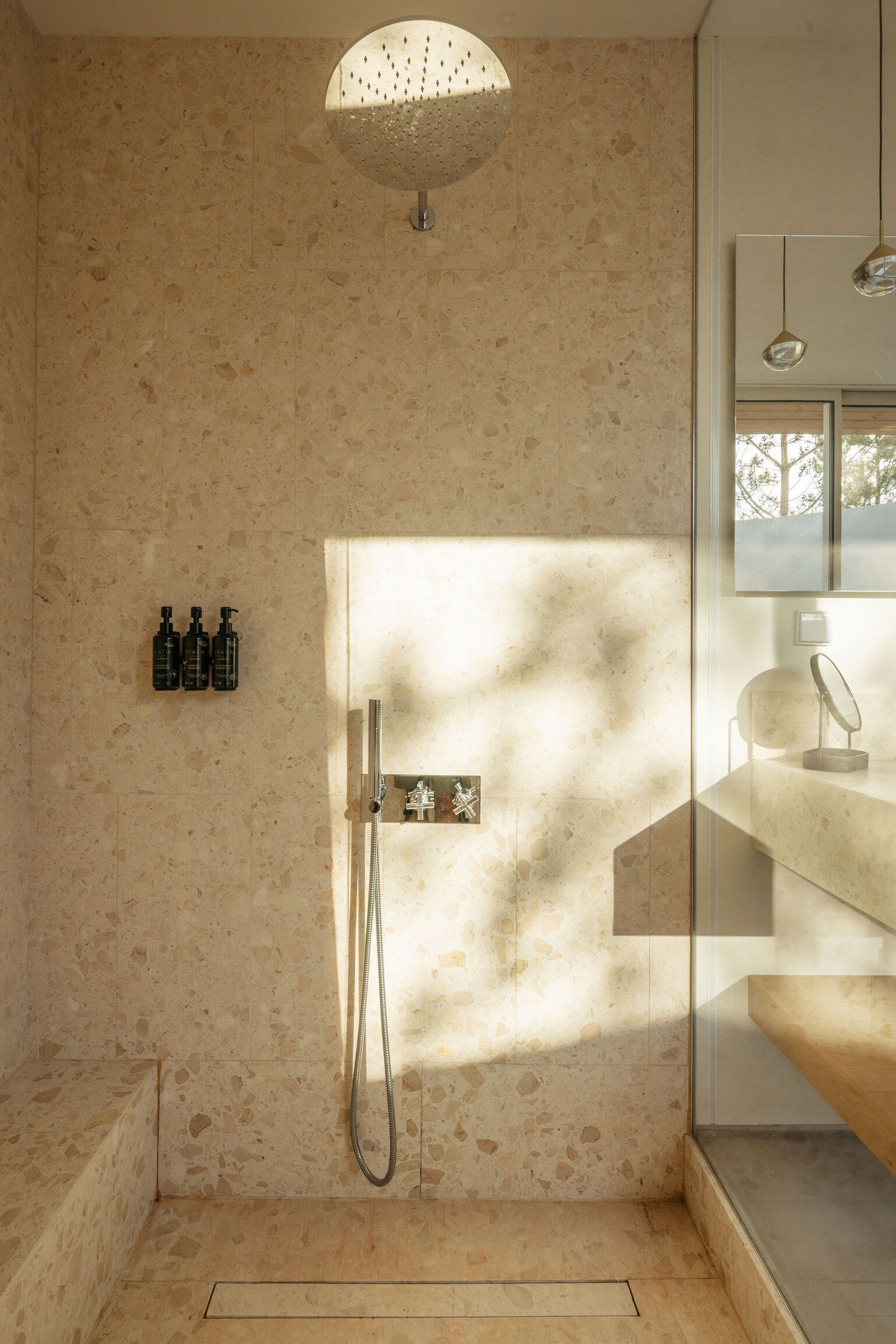 Um banheiro moderno com chuveiro independente, box de vidro e design minimalista.