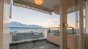 Un balcón con vistas a montañas y a un paisaje urbano.