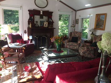 Large living room with fireplace, 6 french doors, 6 windows, overlooks backyard