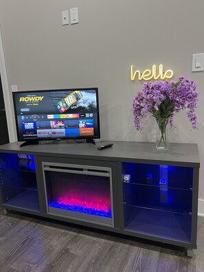 Enjoy entertainment and relaxation in this stylish room with a flat-screen TV, aquarium, and beautiful flowers.